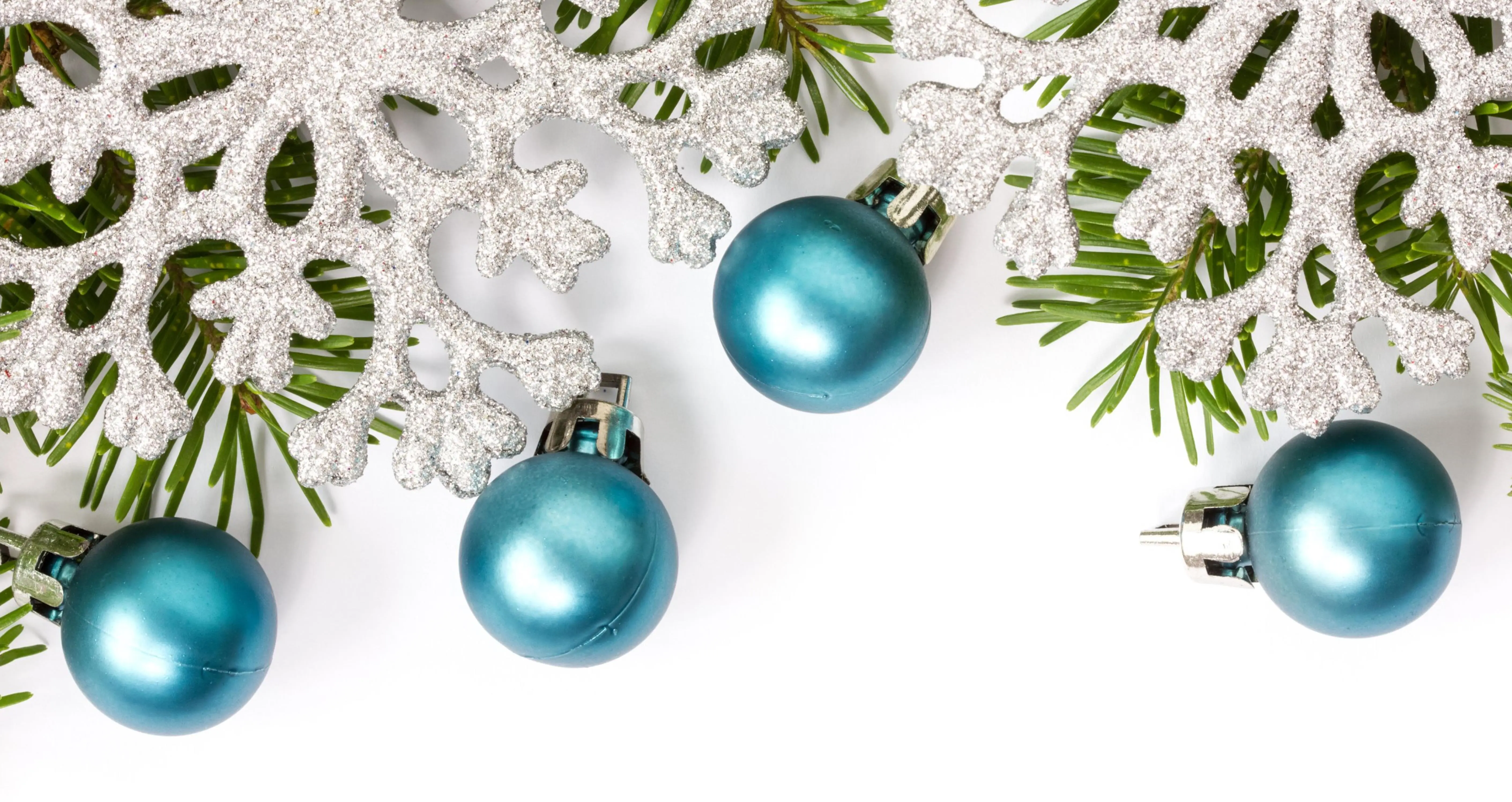 Tannenzweig mit blauen Weihnachtskugeln und Schneeflocken